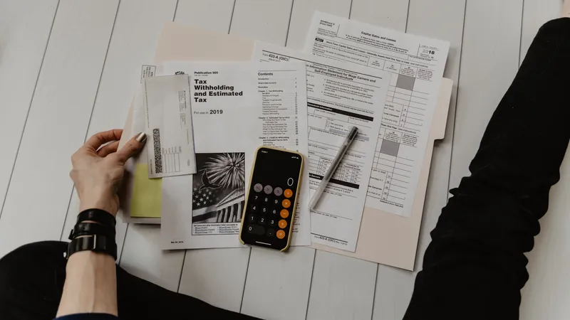A ledger book open beside a laptop on a clean desk, illustrating the divide between financial record-keeping and operational work